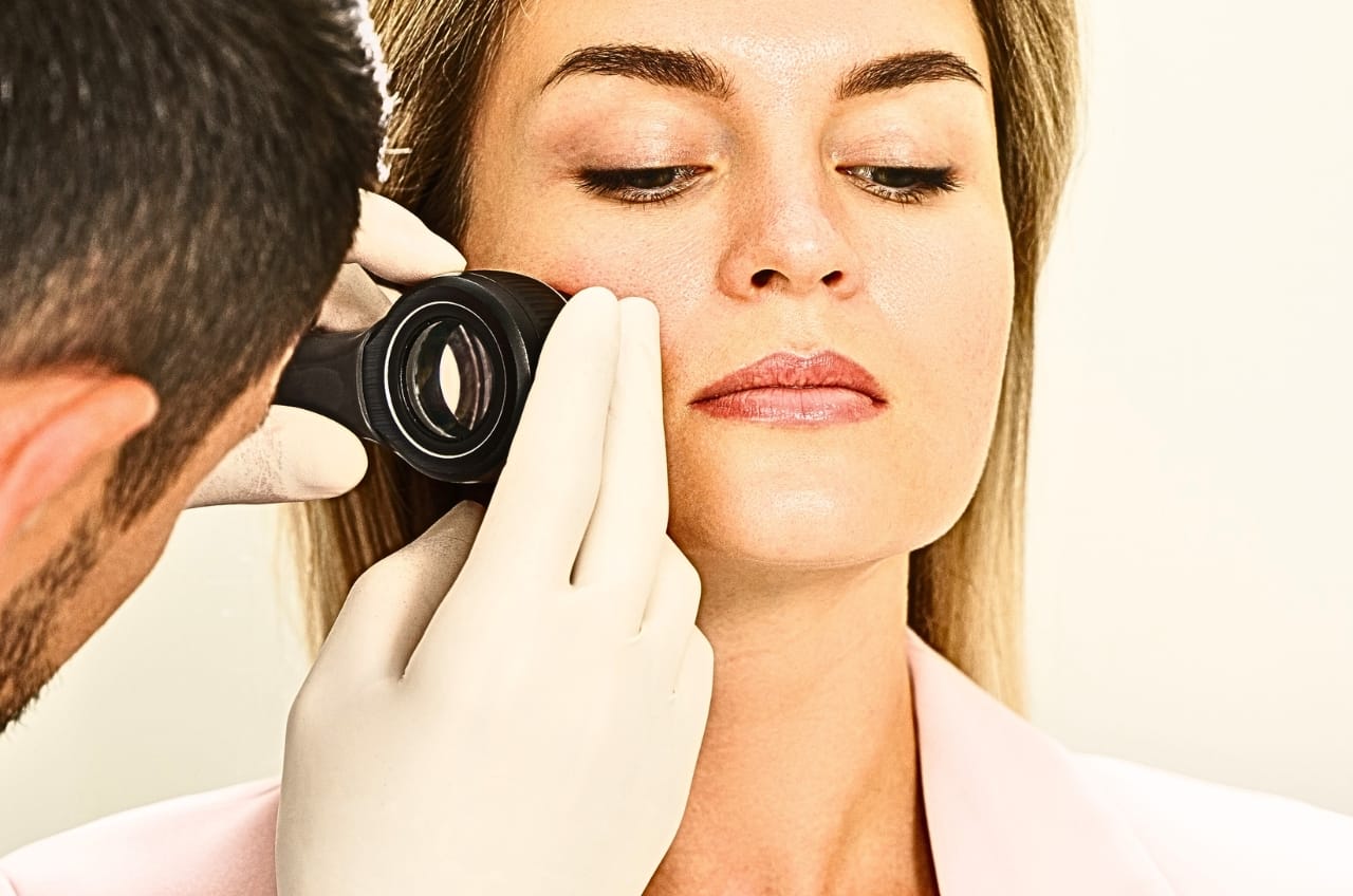 dermatologist examining a womans face