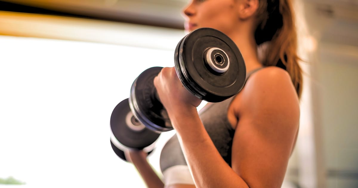 woman lifting dumb bells